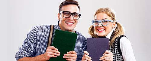 dos estudiantes sonriendo y sosteniendo un libro en sus manos